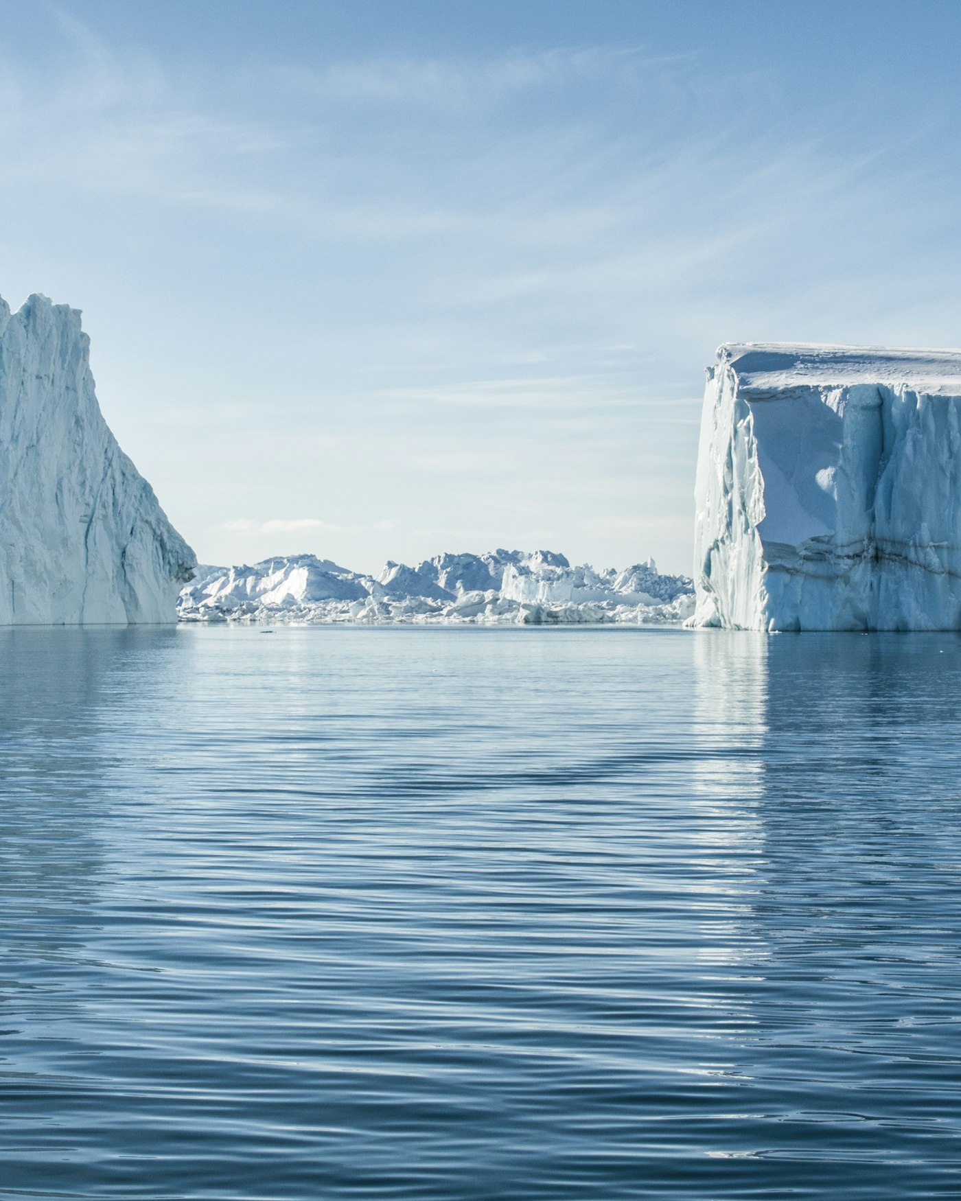 Icebergs crowding the Ilulissat Icefjord in Greenland under a clear sky